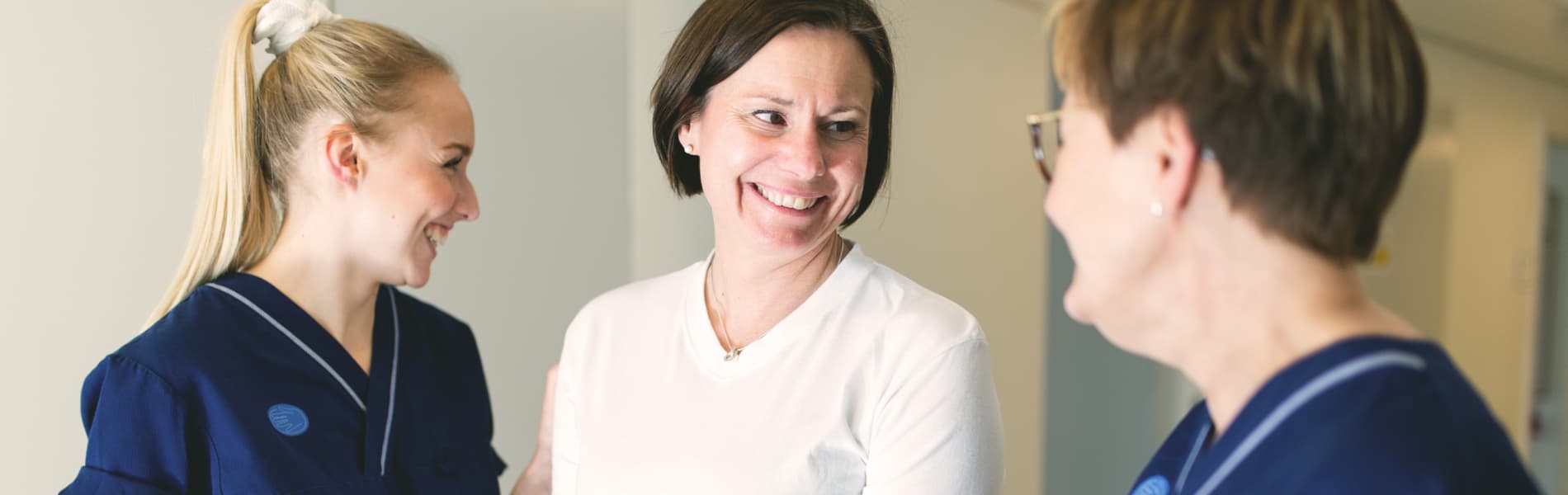 Sjukvårdspersonal assisterar kvinna på kryckor