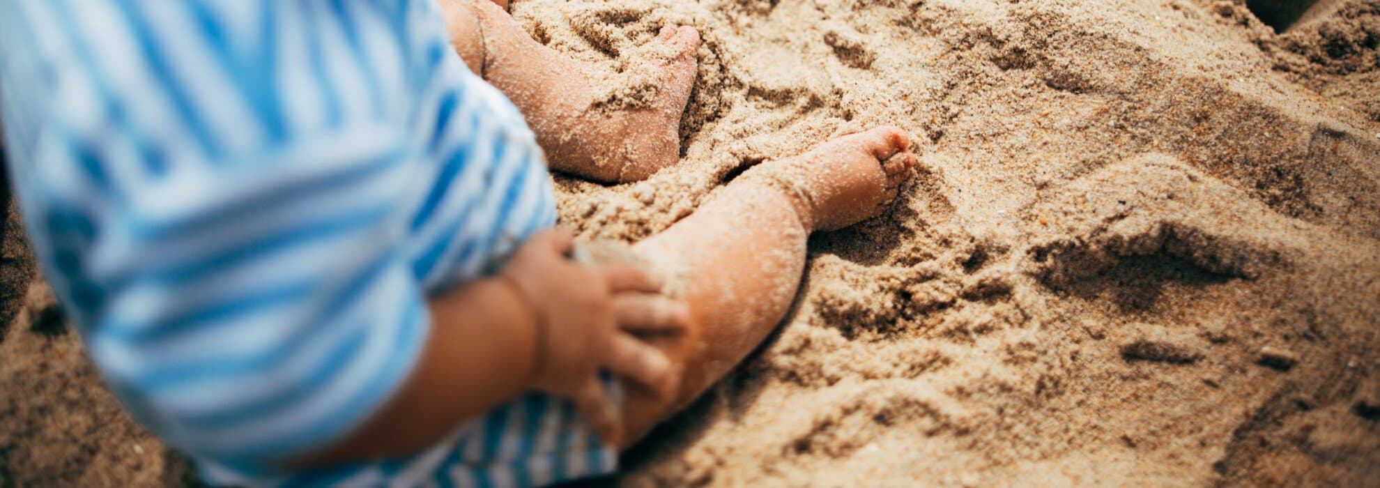 barn sitter på strand