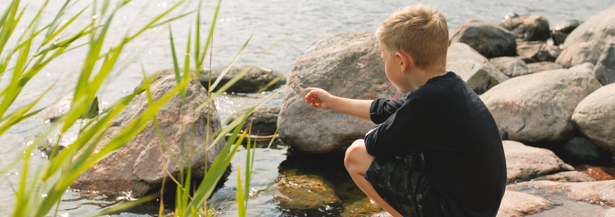 Pojke sitter vid sjö