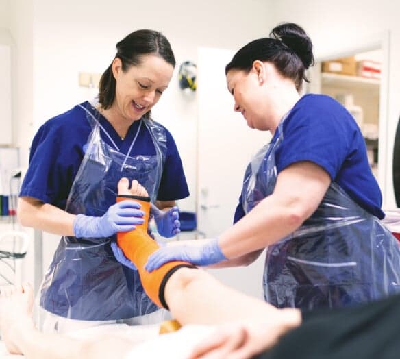 Sjukvårdpersonal behandlar patients fot