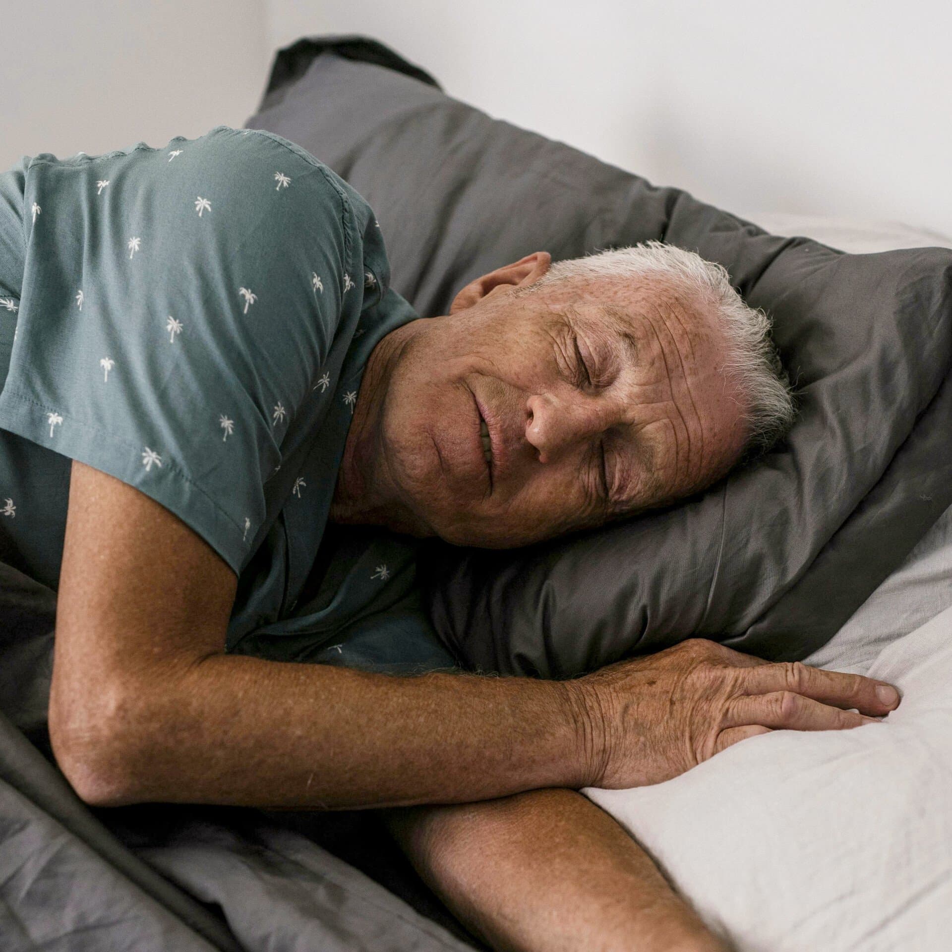 Man som ligger i sängen och sover Man som ligger i sängen och sover