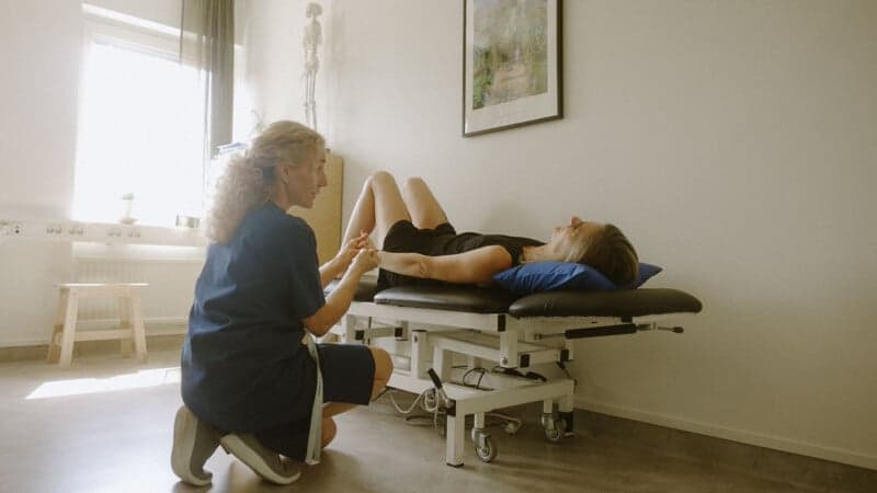 Kvinna ligger på brits