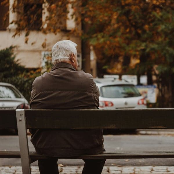 Man sitter på parkbänk Man sitter på parkbänk