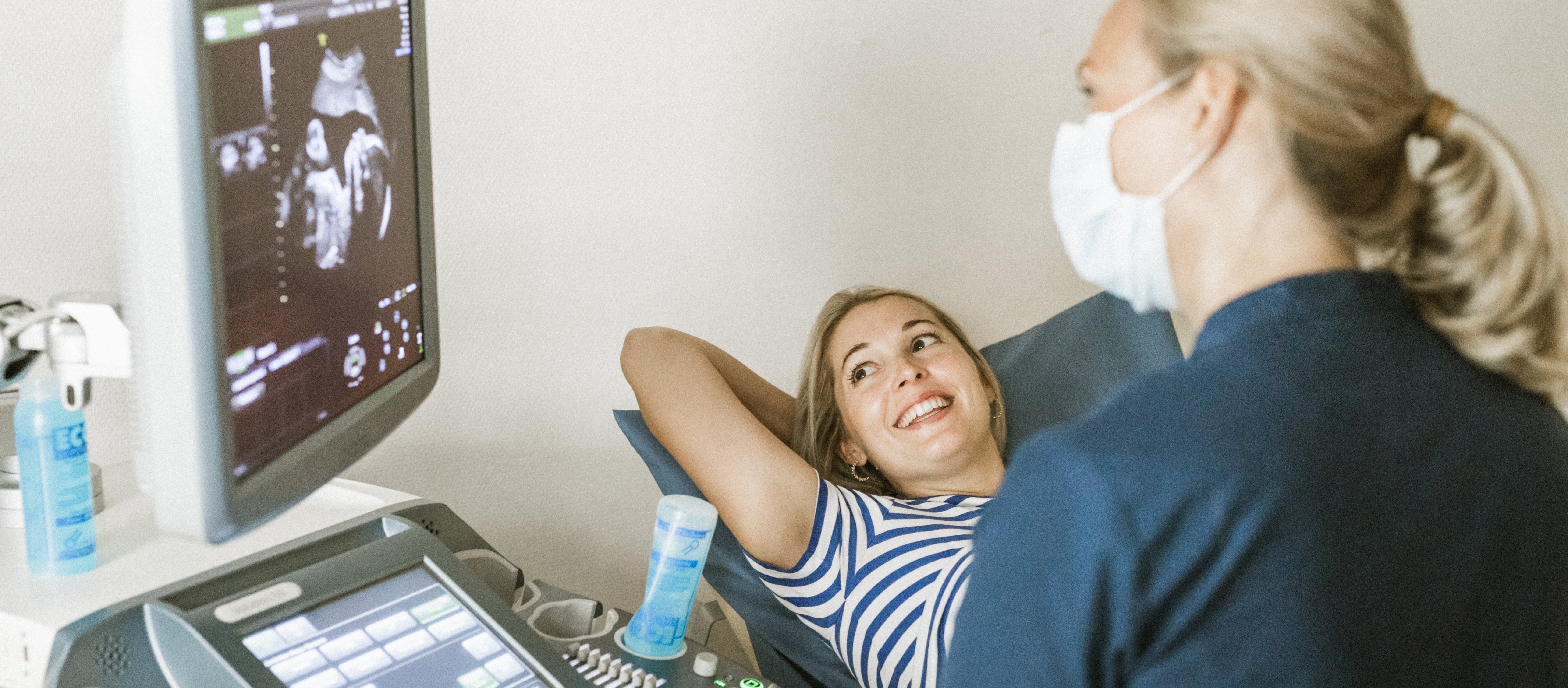 Sjukvårdspersonal samtalar med patient i undersökningsrum Sjukvårdspersonal samtalar med patient i undersökningsrum