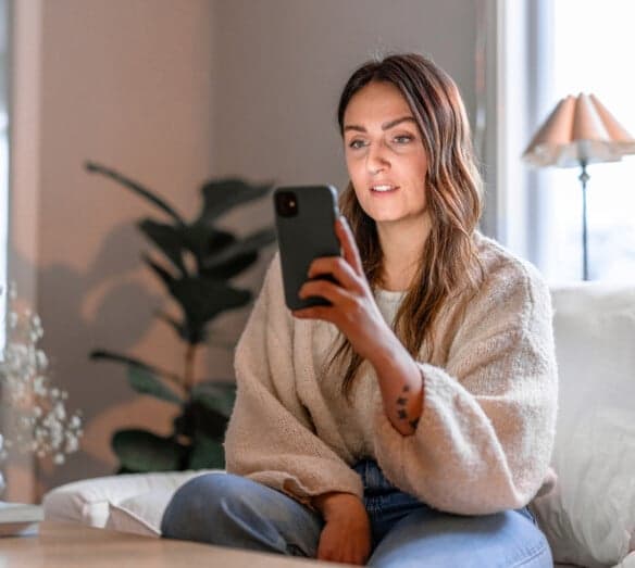 Kvinna tittar på mobiltelefon Kvinna tittar på mobiltelefon