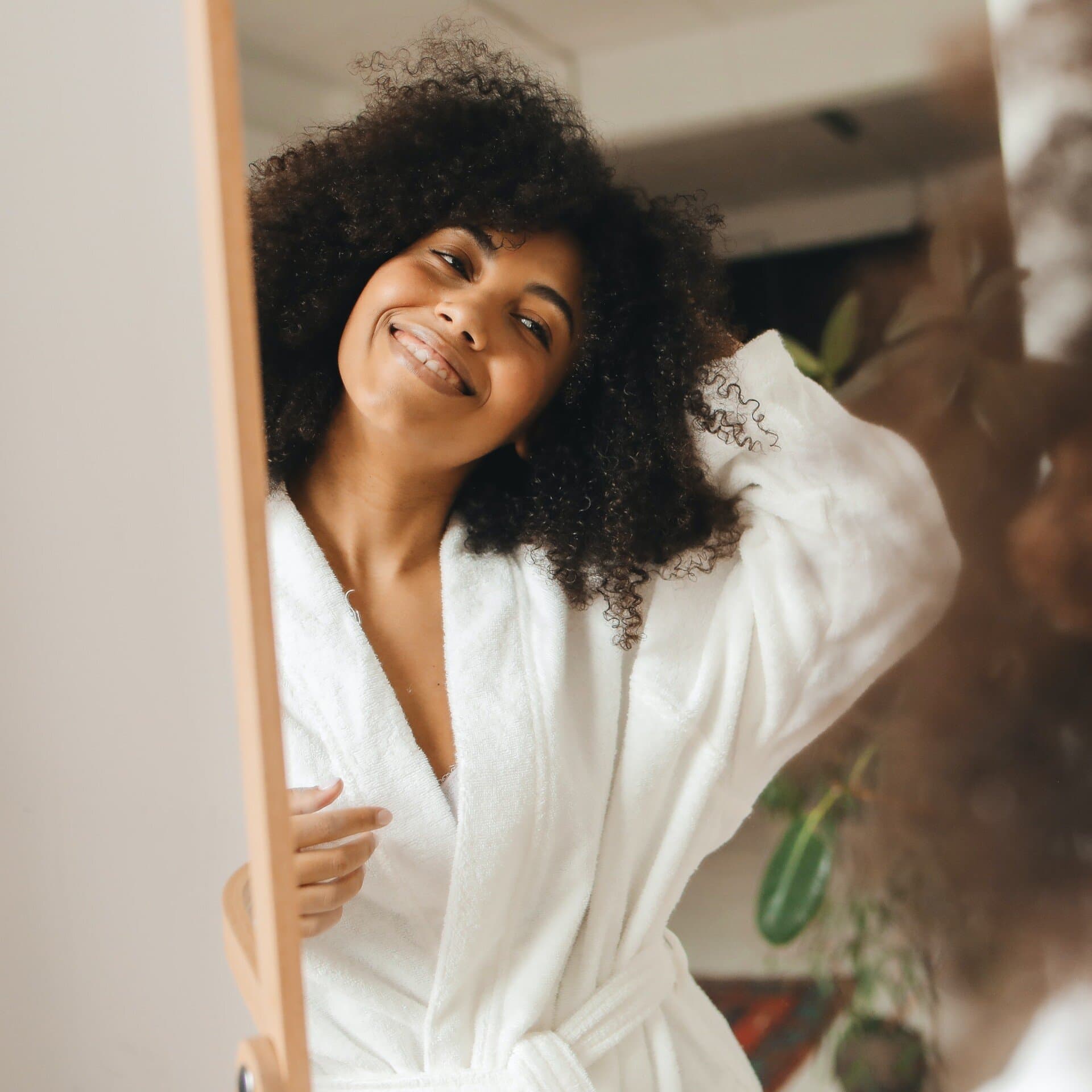 Kvinna kollar sig i spegeln Kvinna kollar sig i spegeln